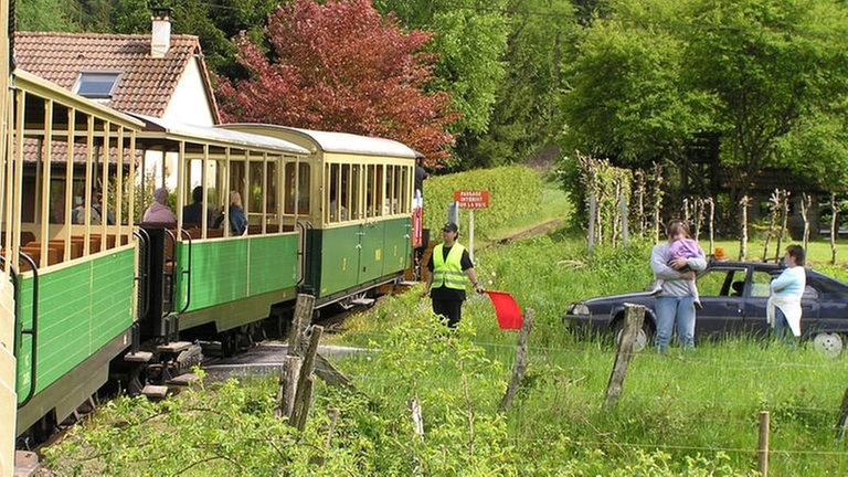 Eine Besonderheit dieser Bahnstrecke: Sie hat keine beschrankten Bahnübergänge. Ein Freiwilliger im Auto fährt voraus und sichert die Bahnübergänge.