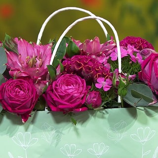 Mit Blumen gefüllte Papiertasche