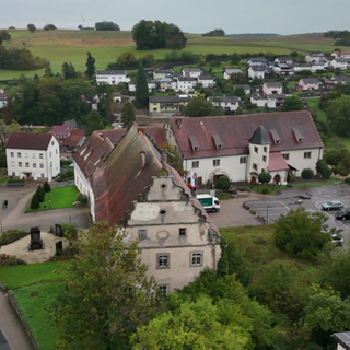 Ein Ehepaar steht vor dem heruntergekommenen Schloss Merchingen