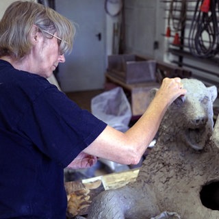 Künstlerin Irmela Maier modelliert an einer Tonfigur von Eisbär Mika.