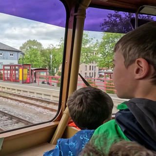 Kinder sitzen in der Führerstand eines Zuges und werden durch Trossingen gefahren.