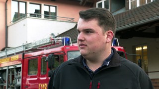 Philip Wenger steht vor einem Feuerwehrauto, das er ersteigert hat.