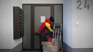 Paketbotin Nadine stellt Pakete an der Haustüre zu.