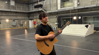 Sänger Myle singt und spielt auf seiner Gitarre.