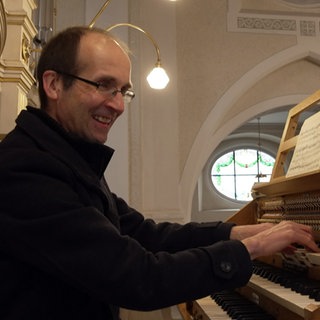 Kantor Christoph Kuppler spielt die Orgel und lächelt dabei.