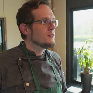 Ein Mann ist zu sehen, der das Grillseminar leitet.