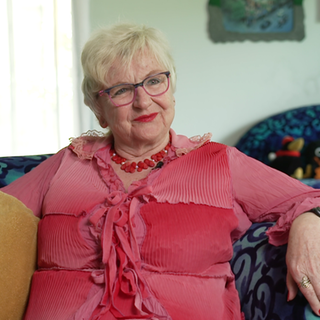 Single Christina sitzt auf dem Sofa.