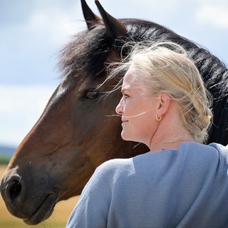 Pferdetrainerin Yvonne Gutsche steht vor einem Pferd.