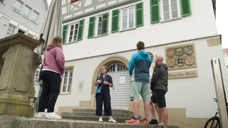Eine Gruppe von Touristen steht in der Innenstadt von Künzelsau.