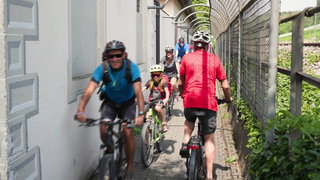 Fahrradfahrer drängen sich auf der Engstelle des Bodensee-Radwegs bei Maurach