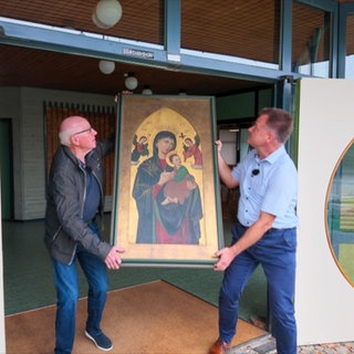 Zwei Männer tragen ein Madonnen-Bild.