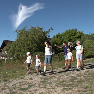 Eine Gruppe Menschen wandert über eine Bergkuppe bei Sasbachwalden.