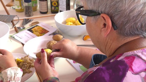Eine Frau schält Kartoffeln.