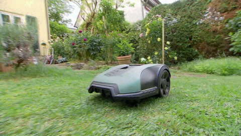 Mähroboter beim Befahren und Mähen einer Rasenfläche