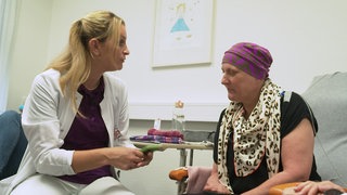Pflegekraft ist mit Patientin im Gespräch
