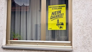Protestplakat gegen Geothermie an einem Fenster in Waldsee