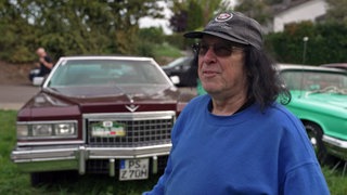 Cadillac-Besitzer vor seinem Auto beim Oldtimer-Wandern in der Südpfalz