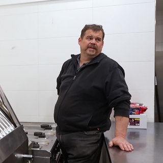 Mann steht in einer Gastroküche.