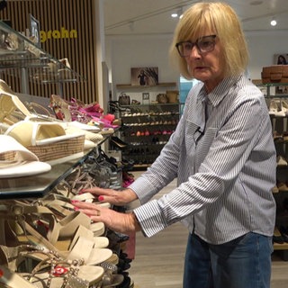 Frau sortiert ein Schuhregal