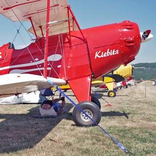 Ein roter Ultraleicht-Doppeldecker, ein sogenanntes Kiebitz-Flugzeug