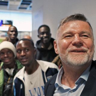 Unternehmer Reiner Rudolphi macht ein Selfie mit seinen neuen Azubis aus Ruanda