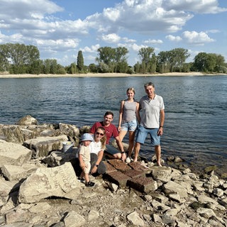 Familie Müller mit ihren gravierten Steinen, die im Niedrigwasser zum Vorschein kommen.