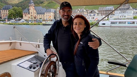 Mann und Frau stehen auf einem Boot auf der Mosel