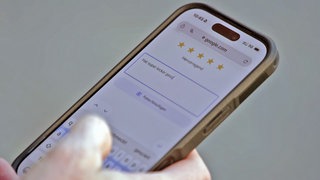 Auf einem Handy vergibt jemand Sterne