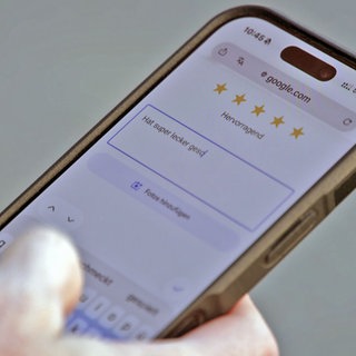 Auf einem Handy vergibt jemand Sterne