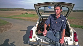Perry Atkinson sitzt auf der Kofferraumkante seines Oldtimers