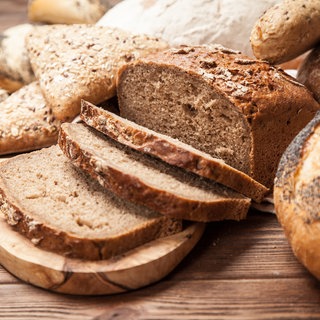 Auf einem Tisch liegen mehrere Scheiben Brot sowie Brötchchen.