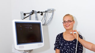 Ein Hausarzt führt eine Ultraschalluntersuchung bei einer Patientin durch.